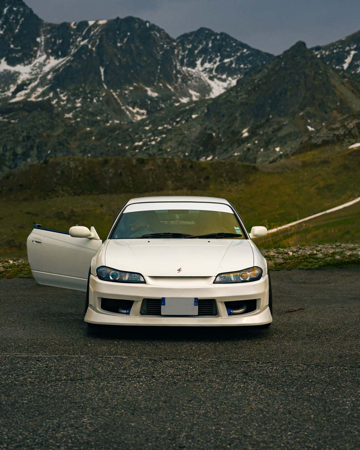 Photo d'une Nissan S15 blanche prise de face avec des montagnes en arrière-plan
